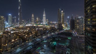 Dubai şehir merkezi silueti Burj Halife ve diğer gökdelenlerle birlikte, gün batımından sonra Dubai 'de, Birleşik Arap Emirlikleri' nin tepesinden panoramik manzara. Geleneksel ve modern binalar. Çevre yolunda trafik