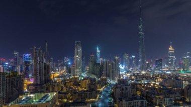 Dubai Şehir Merkezi 'nin ufuk çizgisi Burj Halife ve diğer panoramik manzaralı tüm gece boyunca Dubai, Birleşik Arap Emirlikleri. Gökyüzünde ay var. Geleneksel ve modern binalar.