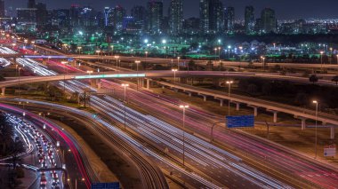Dubai Golf Sahası 'nın arka plan hava gününden geceye geçiş zamanlarında yeşillik ve tekom bölgelerinden oluşan bir manzarası var. Şeyh zayed yolunda trafik kesişiyor.