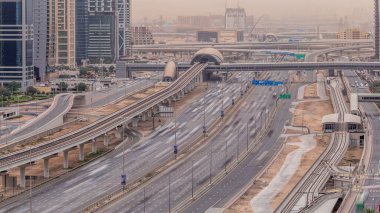 Şeyh Zayed yolu üzerindeki hava manzarası Dubai Marina ve Jlt gökdelenlerini güneş doğduktan sonra kuşattı. Trafik, köprüler ve metro hattı. Tramvay ve metro istasyonu. Birleşik Arap Emirlikleri