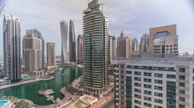 Dubai Marina yerleşim ve ofis gökdelenlerinin deniz manzarası. Yüzen tekneler ve yatlar. Sabah bulutlu bir gökyüzü