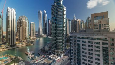 Dubai Marina yerleşim ve ofis gökdelenlerinin deniz manzarası. Gün doğumundan sonraki sabah gölgeler hızla hareket ediyor. Güneş camdan yansıyor. Yüzen tekneler ve yatlar