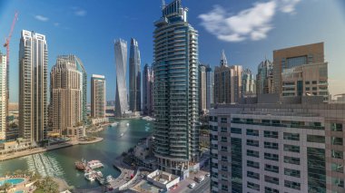 Dubai Marina yerleşim ve ofis gökdelenlerinin deniz manzarası. Gün doğumundan sonraki sabah gölgeler hızla hareket ediyor. Güneş camdan yansıyor. Yüzen tekneler ve yatlar