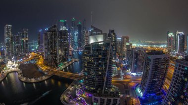Gün batımından sonra Dubai Marina yerleşim ve ofis gökdelenlerinin hava manzarası. Cami ve köprü gününden geceye geçiş zamanı. Yüzen tekneler ve yatlar