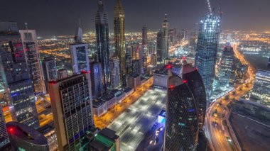 Dubai, BAE 'deki tüm gece boyunca Sheikh Zayed Yolu ve DIFC yakınlarındaki binaların panoramik silueti. Finansal merkezde ve şehir merkezinde aydınlık gökdelenler ve modern kuleler