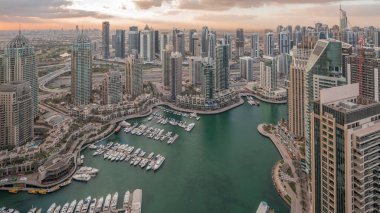 Dubai Marina, gökdelenleri ve Jumeirah göl kulelerini aydınlatmış ve Birleşik Arap Emirlikleri 'nde gece gündüz geçiş zamanlarına kadar panoramik manzara sağlamıştır. Yolda trafik ve yüzen tekneler.