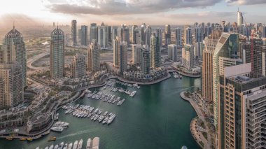 Dubai Marina, gökdelenleri ve Jumeirah göl kulelerini aydınlatmış ve Birleşik Arap Emirlikleri 'nde gece gündüz geçiş zamanlarına kadar panoramik manzara sağlamıştır. Yolda trafik ve yüzen tekneler.