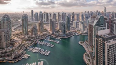 Dubai Marina, gökdelenleri ve Jumeirah göl kulelerini aydınlatmış ve Birleşik Arap Emirlikleri 'nde gece gündüz geçiş zamanlarına kadar panoramik manzara sağlamıştır. Yolda trafik ve yüzen tekneler.