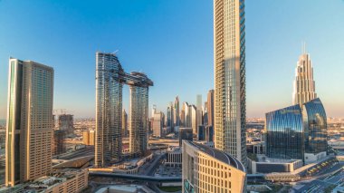 Yeni kulelerin ve yoğun yolları olan yüksek binaların havadan görünüşü tüm gün boyunca uzun gölgelerle Dubai şehir merkezinden hızla ilerlerken otoyol, Dubai, Birleşik Arap Emirlikleri 'nde trafik vardı.