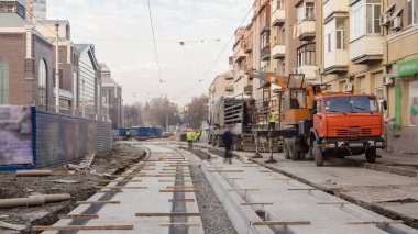 Tramvay rayları üzerinde yol timelapse beton tabaklarda vinç onların kamyondan boşaltma aşamasında. Tramvay yeniden inşası süreci izler
