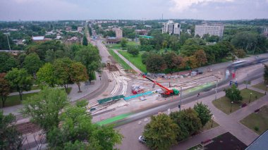 Tramvay rayları onarılan ve panoramik bakım yapan yol inşaatı. Kavşağın ortasına vinç üstüne beton plakalar ve bloklar yerleştirip boşaltıyorlar. Değiştirme