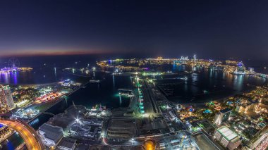 Palm Jumeirah Adası gün gece geçiş timelapse için hava gün batımı manzarası. Üstten görünüm ışıklı Villaları, otelleri ve yatlar ile akşam. Yeni cruise terminal inşaat süreci