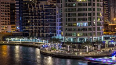 Geçen tekneler ve avuç içi gün gece ile promenade ile lüks Dubai Yat Limanı kanal timelapse geçiş, yukarıdan bakışta akşam güneş battıktan sonra Top. Dubai, Birleşik Arap Emirlikleri