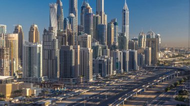 Dubai Yat Limanı gökdelenler hava üstten görünüm Jlt üzerinden sabah Dubai timelapse, BAE güneş doğarken sırasında. Modern kule uzun gölgeler aşağıya taşınması ve Şeyh zayed yolu üzerinde trafik ile.