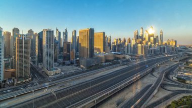 Dubai Yat Limanı gökdelenler hava üstten görünüm sabah Jlt günbatımı içinde Dubai timelapse, Birleşik Arap Emirlikleri için gün boyunca. Modern kule uzun gölgeler aşağıya taşınması ve Şeyh zayed yolu üzerinde trafik ile.