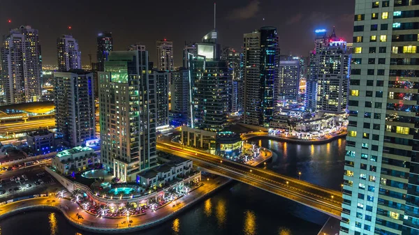 Dubai Marina gezinti güvertesi ve kanalı, gün batımından sonra Dubai, BAE 'de yüzen yat ve tekneler ile gündüz hava manzaralı. Modern kuleler, köprü ve trafik yukarıdan geliyor.