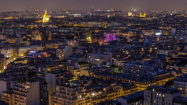 Paris 'teki evlerin çatılarının üstündeki hava panoraması gece gündüz geçiş zamanı. Günbatımından sonra aydınlanan kubbe ve diğer manzaralarla akşam manzarası