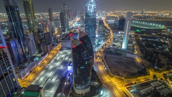 Dubai, BAE 'deki gece havası sırasında Sheikh Zayed Yolu ve DIFC yakınlarındaki binaların panoramik silueti. Modern kuleler ve aydınlık gökdelenler finans merkezi ve şehir merkezinde ışıklar değişiyor.