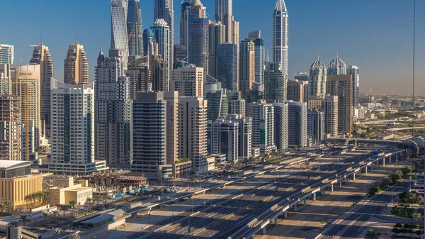 Dubai Yat Limanı gökdelenler hava üstten görünüm Jlt üzerinden sabah Dubai timelapse, BAE güneş doğarken sırasında. Modern kule uzun gölgeler aşağıya taşınması ve Şeyh zayed yolu üzerinde trafik ile.