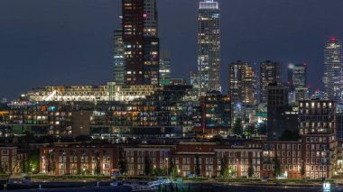 Rotterdam, Hollanda 'daki Katendrecht yarımadası ve Maashaven limanının hava ve gece geçiş zamanı. Şehir silueti modern gökdelenler ve geleneksel Hollanda rıhtım evleri