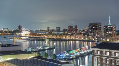Rotterdam, Hollanda 'daki Katendrecht Yarımadası ve Maashaven Limanı' nın panoramik hava ve gece geçiş zamanı. Şehir silueti modern gökdelenler ve geleneksel Hollanda rıhtım evleri