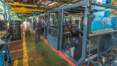 Konveyör montajı, traktörün gövdesini büyük endüstriyel fabrika zaman diliminde sahneleyecek. Kabin montajı, kurulum parçaları özel bir masada.