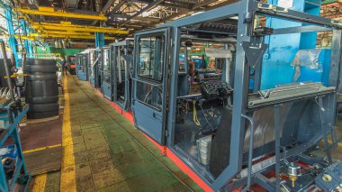 Konveyör montajı, traktörün gövdesini büyük endüstriyel fabrika zaman diliminde sahneleyecek. Kabin montajı, kurulum parçaları özel bir masada.