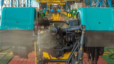 Konveyör montajı, traktörün gövdesini büyük endüstriyel fabrika zaman diliminde sahneleyecek. Çerçeve montajı, çamurluk kurulumu ve montajlanan diğer parçalar