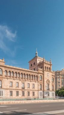 Panorama, İspanya, Valladolid Plaza de Zorrilla 'da Süvari Akademisi zaman çizelgesi gösteriyor. Karmaşık mimarisi olan tarihi askeri bina, mavi bulutlu gökyüzünün altında kalabalık şehir manzaralarıyla çevrili.