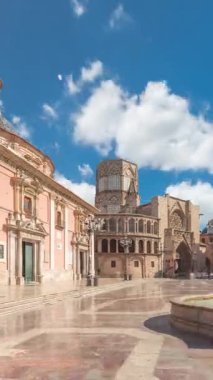 Valencias Plaza de la Virgen 'in panoramik zaman atlaması, Turia Fountain, Cathedral ve Basilica de la Virgen de los Desamparados' un mavi bulutlu gökyüzü altında sergilenmesi