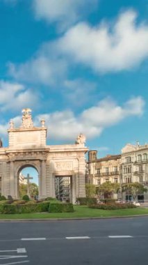 İspanya, Valencia 'da La Porta de la Mar zaman atlaması. Bir zamanlar ortaçağ duvarlarının bir parçası olan bu neoklasik kapı kalabalık bir kavşağın üzerinde duruyor. Gün batımında parlak bir gökyüzünün altında değerli bir şehir simgesi.