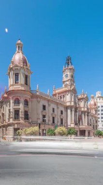 Panorama, Valencia Belediyesi Ajuntament de Valencia 'nın Plaza de Ayuntamiento' daki zamanını gösteriyor. Mavi gökyüzünün altında saat kulesi olan tarihi bir bina. İspanya 'nın ana meydanında gezinen insanlar