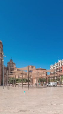 Panorama, İspanya, Valencia 'daki Plaza de la Reina' nın zaman çizelgesini gösteriyor. Tarihi bir kilise kulesi, hareketli kafeler ve sıcak Akdeniz mavi gökyüzünün altında merkezi bir çeşmesi olan canlı bir meydan..