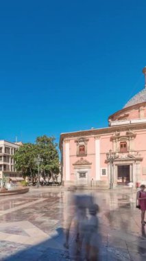 Valencias Plaza de la Virgen 'in zaman çizelgesini gösteren panorama, Katedral, Basilica de la Virgen de los Desamparados ve Turia Fountain' in mavi gökyüzü altında sergileniyor.