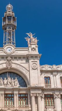 Valensiya 'daki tarihi posta ofisi Palau de les Comunicacions Belediye Meydanı Plaza del Ayuntamiento' da. Süslü cephe, yeşil ağaçlar ve İspanya şehir merkezinde mavi bir gökyüzü..