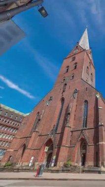 St. Peters Kilisesi ya da Hauptkirche St. Petri zaman atlaması Hamburg, Almanya 'da. Bu Protestan Luteryan kilisesinde yüksek kulesi, trafiği ve mavi gökyüzü arkaplanı olan gotik mimari yer almaktadır.