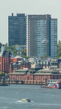 Hamburg 'daki Altona Balık Pazarı' nın zaman çizelgesi. Elbe Nehri 'ne yansıyan binaların olduğu tarihi bir pazar. Ticaret, kültür ve canlı liman manzarası. İskele vinçleri ve gökdelenler