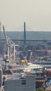 Hamburg kargo limanının hava zaman çizelgesi Elbe Nehri 'ndeki konteyner terminalleri, vinçler ve kargo gemileri. Rüzgar santrallerinde çalışıyorum. Tekneler ve gemiler geçiyor, deniz manzarası. Almanya