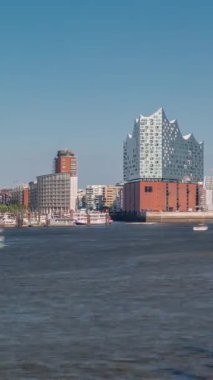 Hamburgs ikonik Elbphilharmonie konser salonunun Timelapse 'ı. Önünde tarihi bir kargo gemisi var. Arka planda Uberseebrucke ve Niederhafen, Hafencity rıhtımında. Almanya