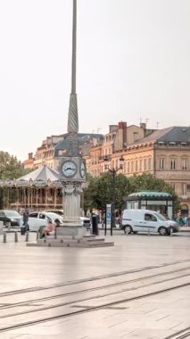 Günbatımında Place de la Comedie Timelapse, Bordeaux, Fransa 'da üçgen bina ve modern tramvay. Gölgeler ön cephede ilerler ve saatli bir sokak lambası bu şehir simgesine zarafet katar.