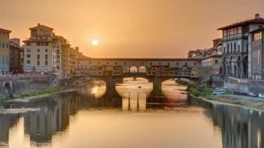 Florence Timelapse, İtalya 'daki Arno Nehri üzerindeki Florence Ponte Vecchio' nun günbatımı manzarası. Floransa mimarisi. Floransa 'nın ana simgelerinden biri.