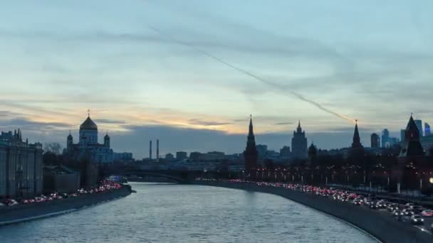 モスクワ・クレムリンとモスクワ市のビジネスセンターのアンサンブルは、冬の日から夜のタイムラプスハイパーラプスでモスクワ川を渡る — ストック動画