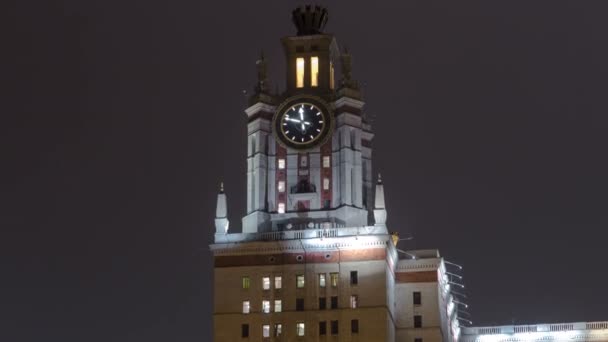 Torre con reloj del edificio principal de la Universidad Estatal de Moscú en Sparrow Hills en invierno hiperlapso timelapse en la noche — Vídeos de Stock