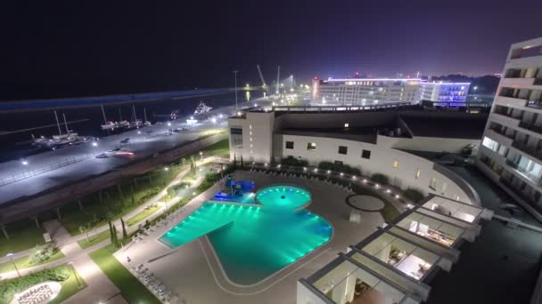 Playa de mar, piscina y yate en el mar por la noche timelapse. Vista superior — Vídeo de stock