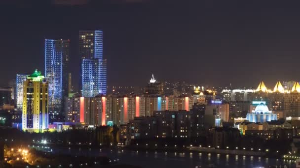 Vista nocturna elevada sobre el centro de la ciudad y el distrito financiero central con torres Timelapse desde la azotea, Kazajstán, Astana — Vídeos de Stock