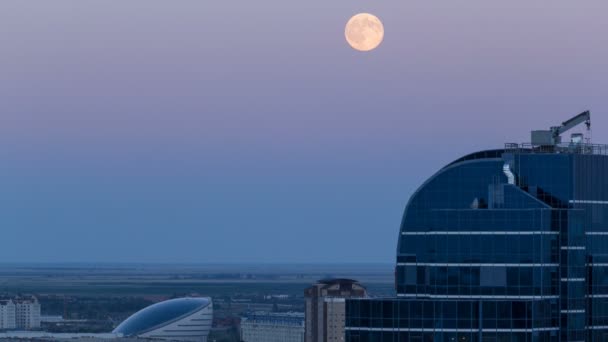 Nazarbayev Merkezi ve mavi kule, gün batımından sonra dolunay yükseliyor. Astana, Kazakistan — Stok video