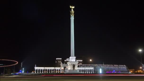 Estela monumento Cazaque Eli com pássaro Samruk e Palácio da Independência timelapse hiperlapse à noite . — Vídeo de Stock