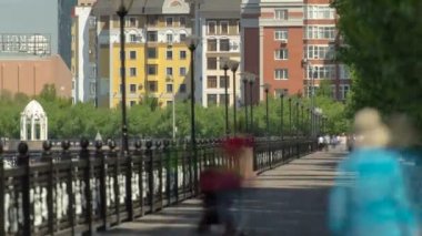 nehir Ishim, insanlar waterfront timelapse, binalar, tesislerinde, tratuar ve ağaçlar üzerinde yürümek. Güneşli bir gün. Astana, Kazakistan