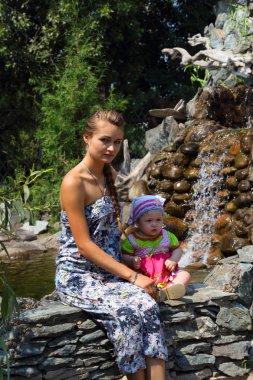 Kız ve Şelalesi hakkında oturan çocuk