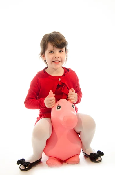 Dolce bambina che gioca con un peluche cavallo giocattolo saltare isolat — Foto Stock